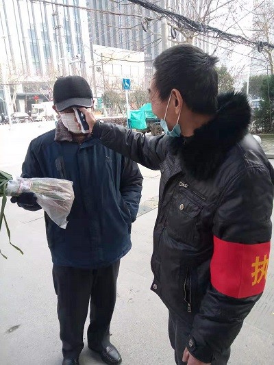 红色物业助力疫情防控工作，测量来访人员.JPG