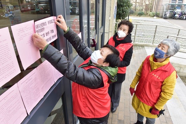7：井岗镇兴民社区的金大地小区里，“红色管家”正在张贴温馨提示语。.JPG