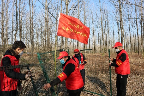 图4：十八岗村义务巡逻护村队在修补水源地隔离网。.JPG