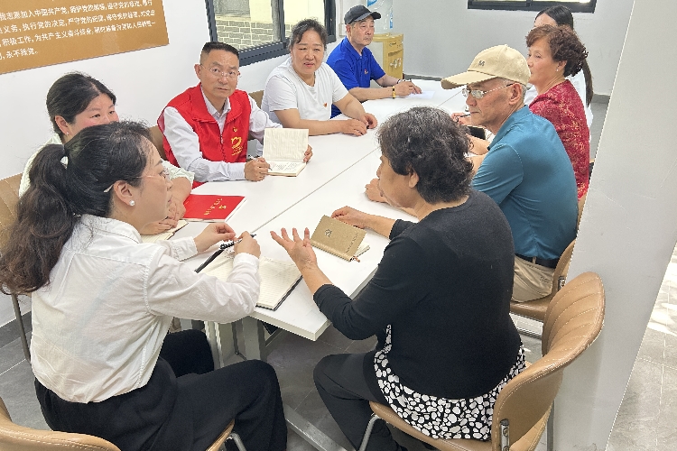 丁香社区在丁香家园廊亭召开廊亭议事会，和党员们一起讨论电梯安全、安装充电桩等小区治理方面问题.jpg